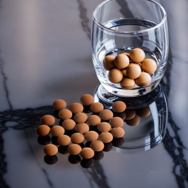 Verre avec billes QELBY posé sur du marbre